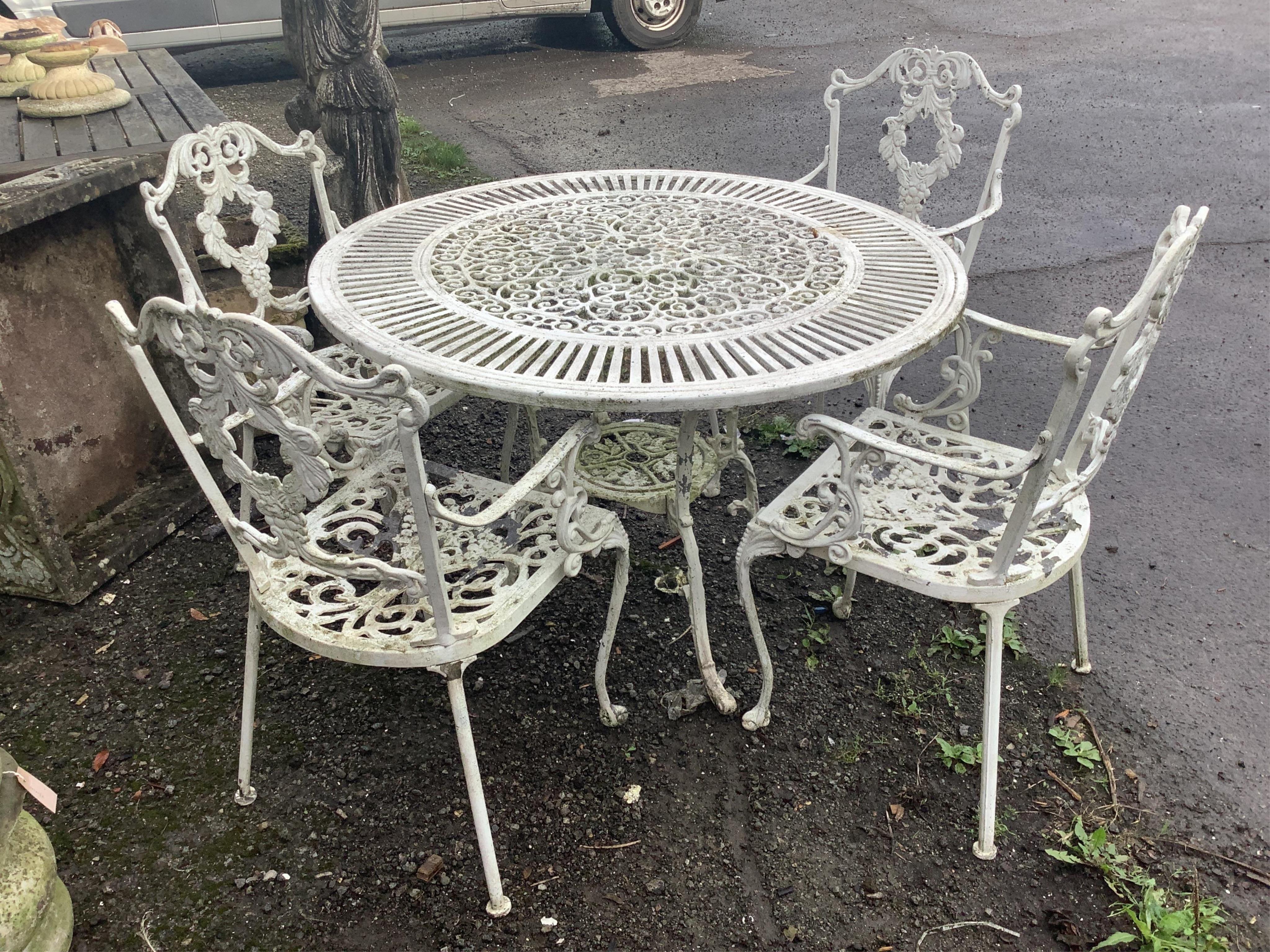 A Victorian style painted aluminium circular garden table, diameter 106cm, height 70cm and four chairs. Condition - good